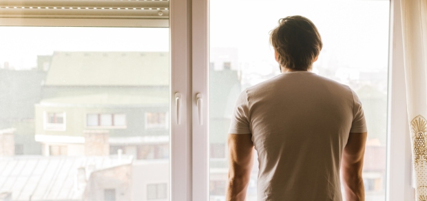 man looking out a window