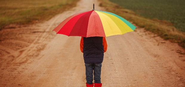 a person holding a rainbow umbrella