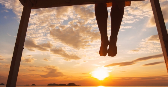 legs dangling off a pier